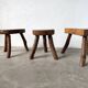 Set of three rustic solid wood tripod stools.