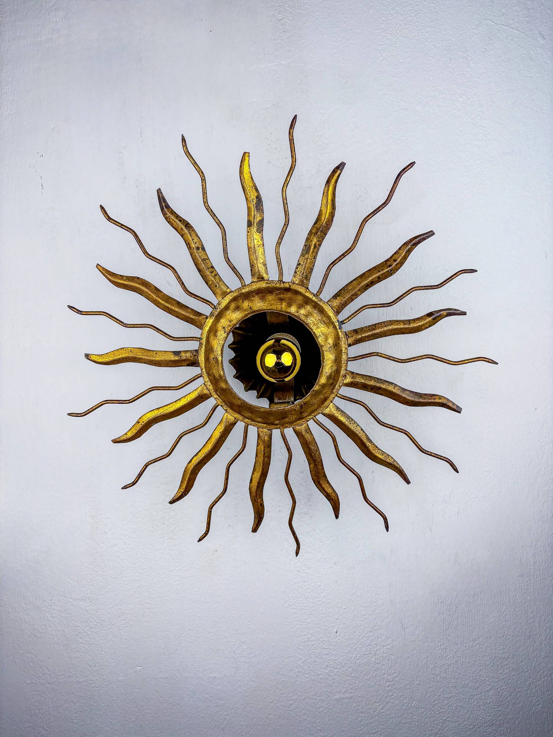 Brutalist sunburst ceiling light – gilt iron rays & exposed bulb, France, 1960s
