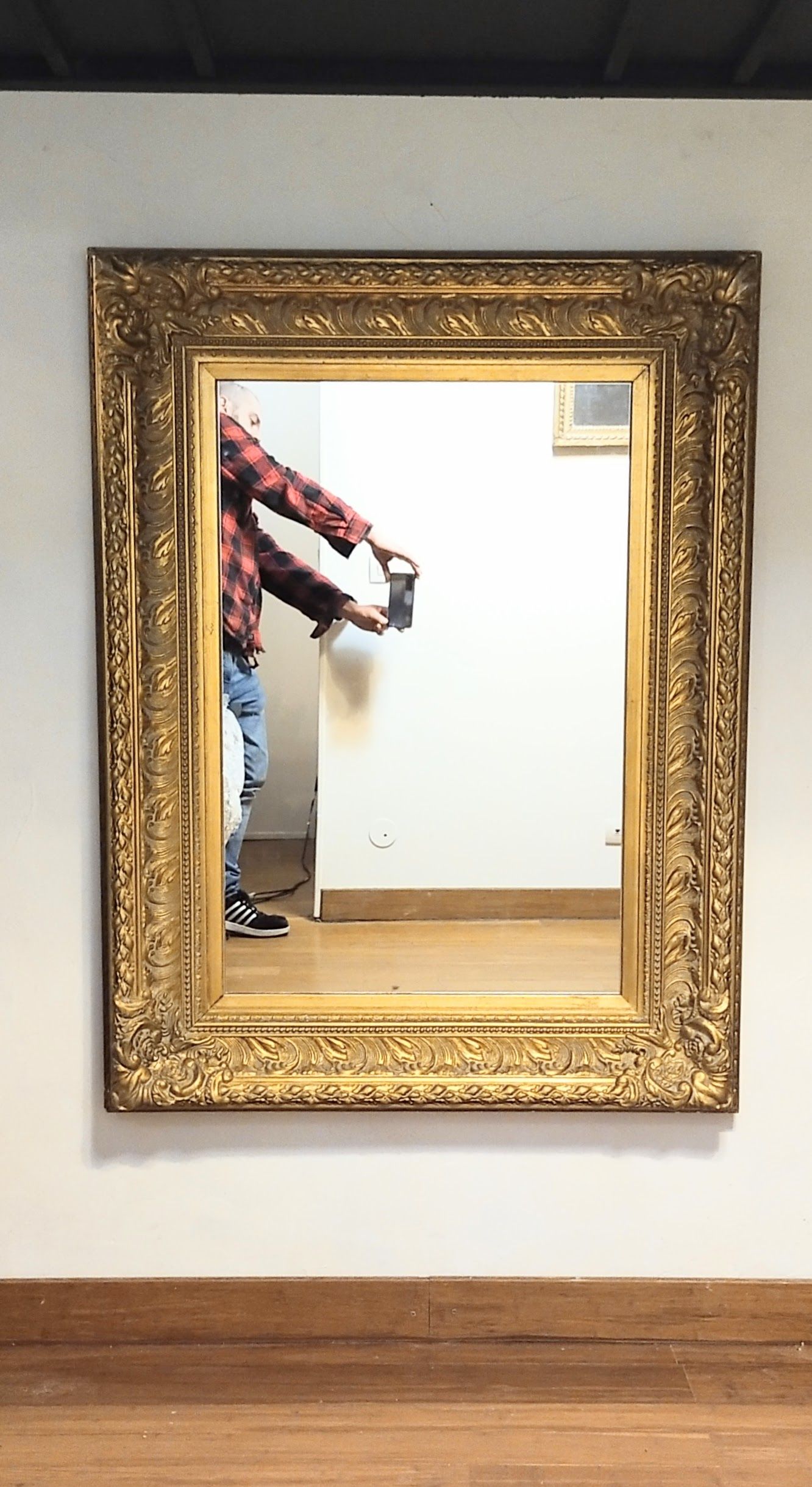 Mirror with large molded frame in gilded plaster with gold leaf