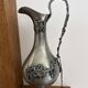 Ewer in pewter surrounded by vine branches with g