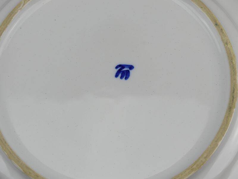 Old earthenware dish with a floral basket decoration.