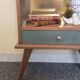 Renovated vintage bedside table in wood, with tapered legs – Matt green & gold background