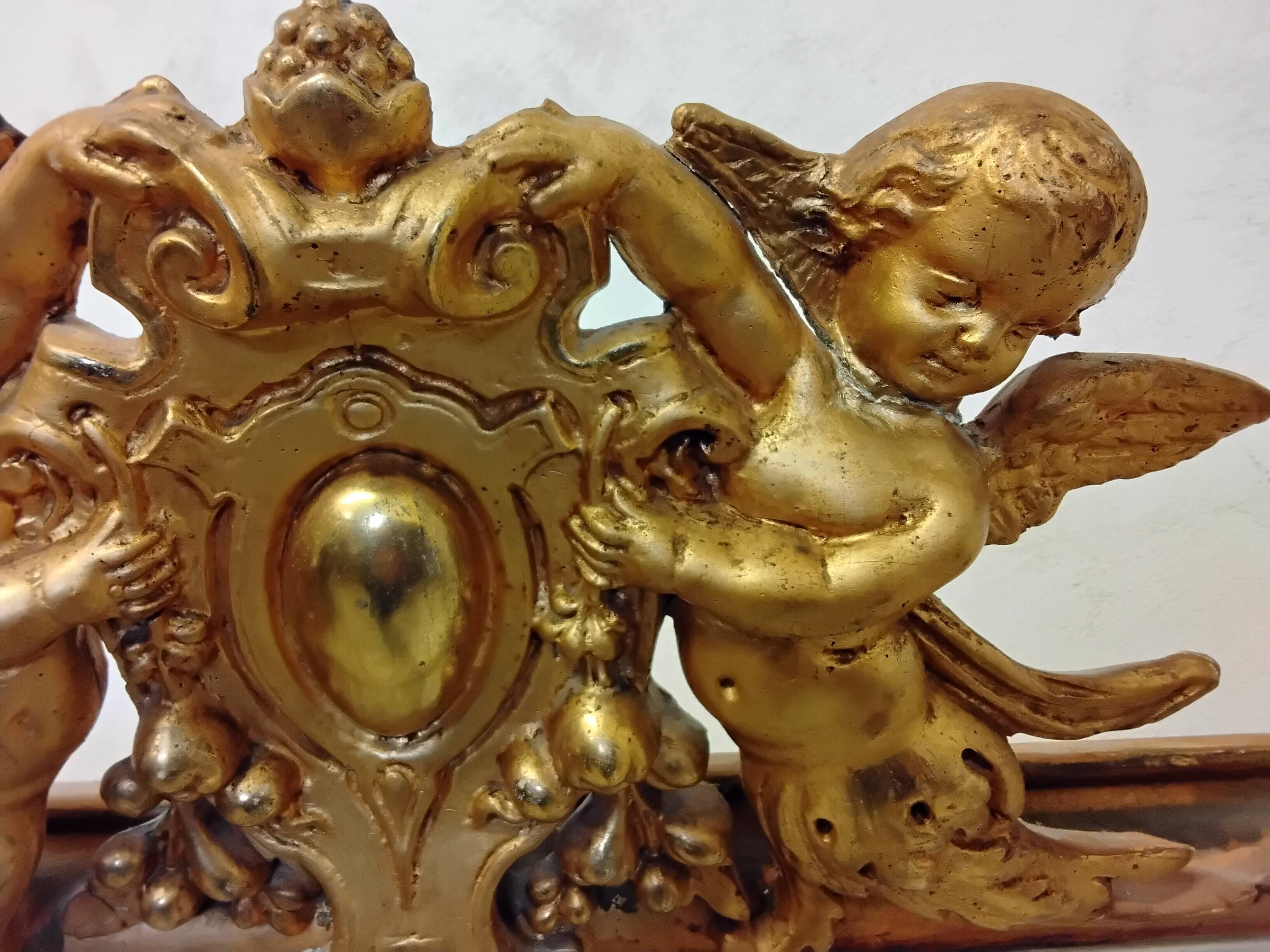 Antique mirror with a gilded frame and cherubs.
