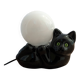 Black cat playing with its globe table lamp