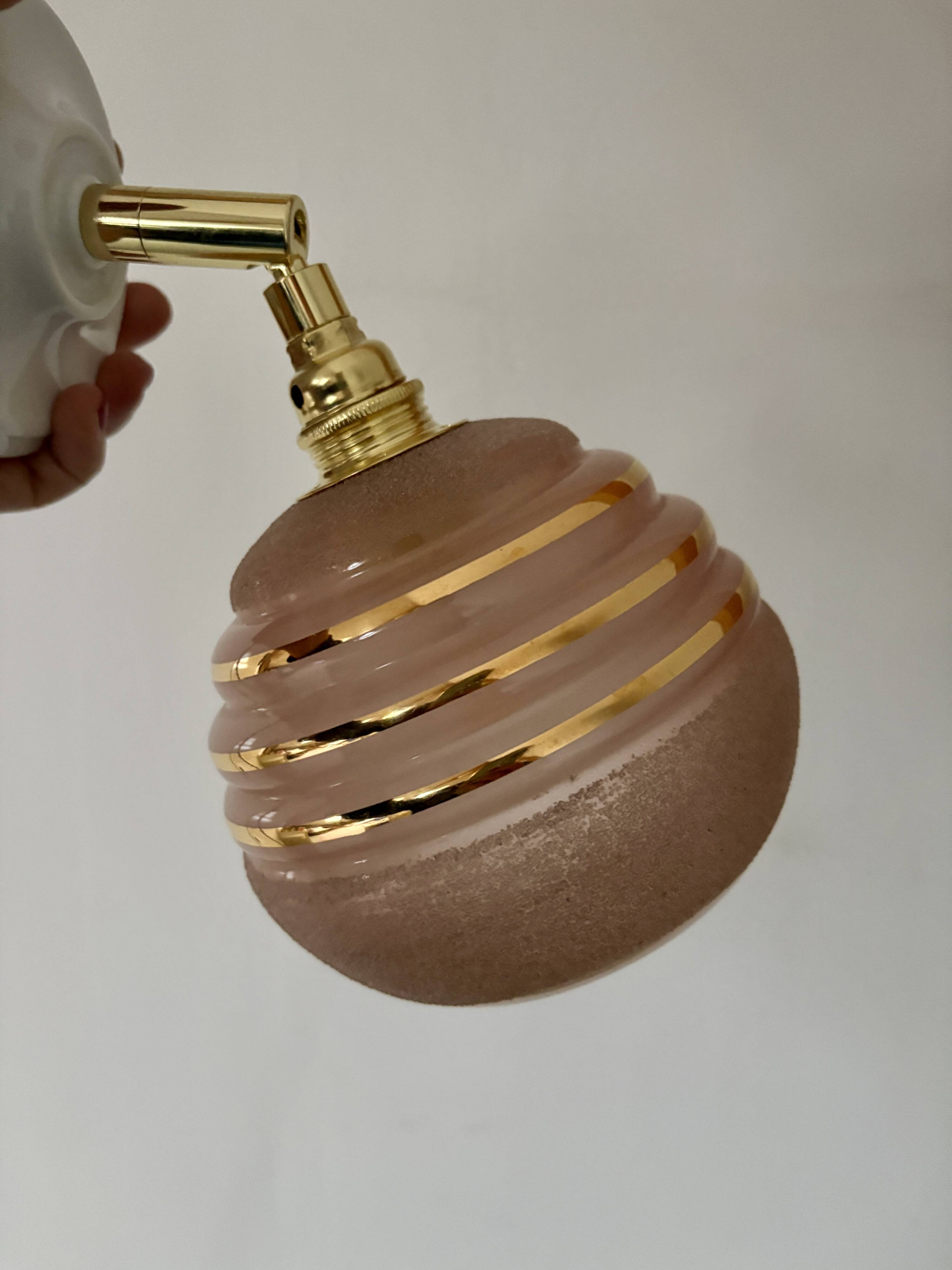 Vintage globe wall light in frosted pink and gold glass.