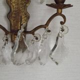 Pair of French antique brass double wall lights with assorted crystals.