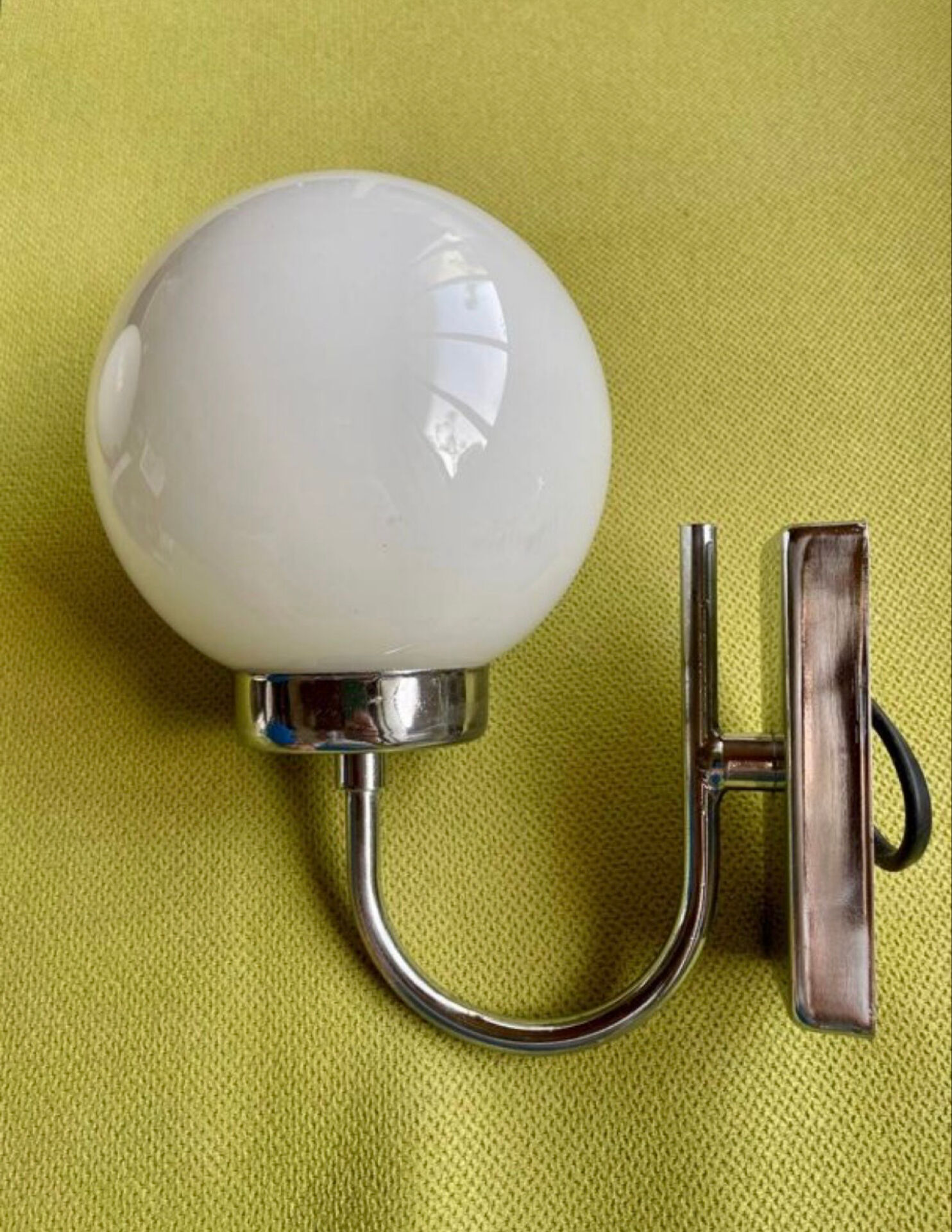 Pair of chrome metal wall lights with white glass globe.
