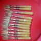 12 Cake forks. Around 1930. Golden metal and yellow Bakelite handle.