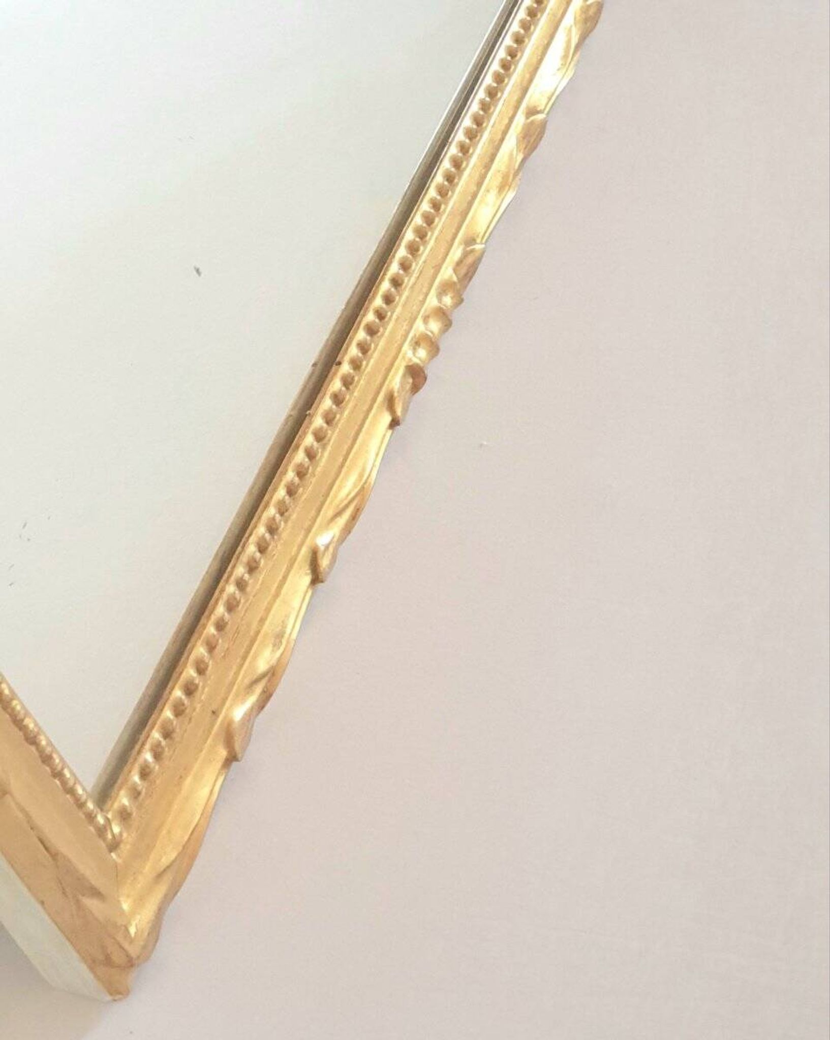 Golden mirror in the Louis XVI style from the 20th century.