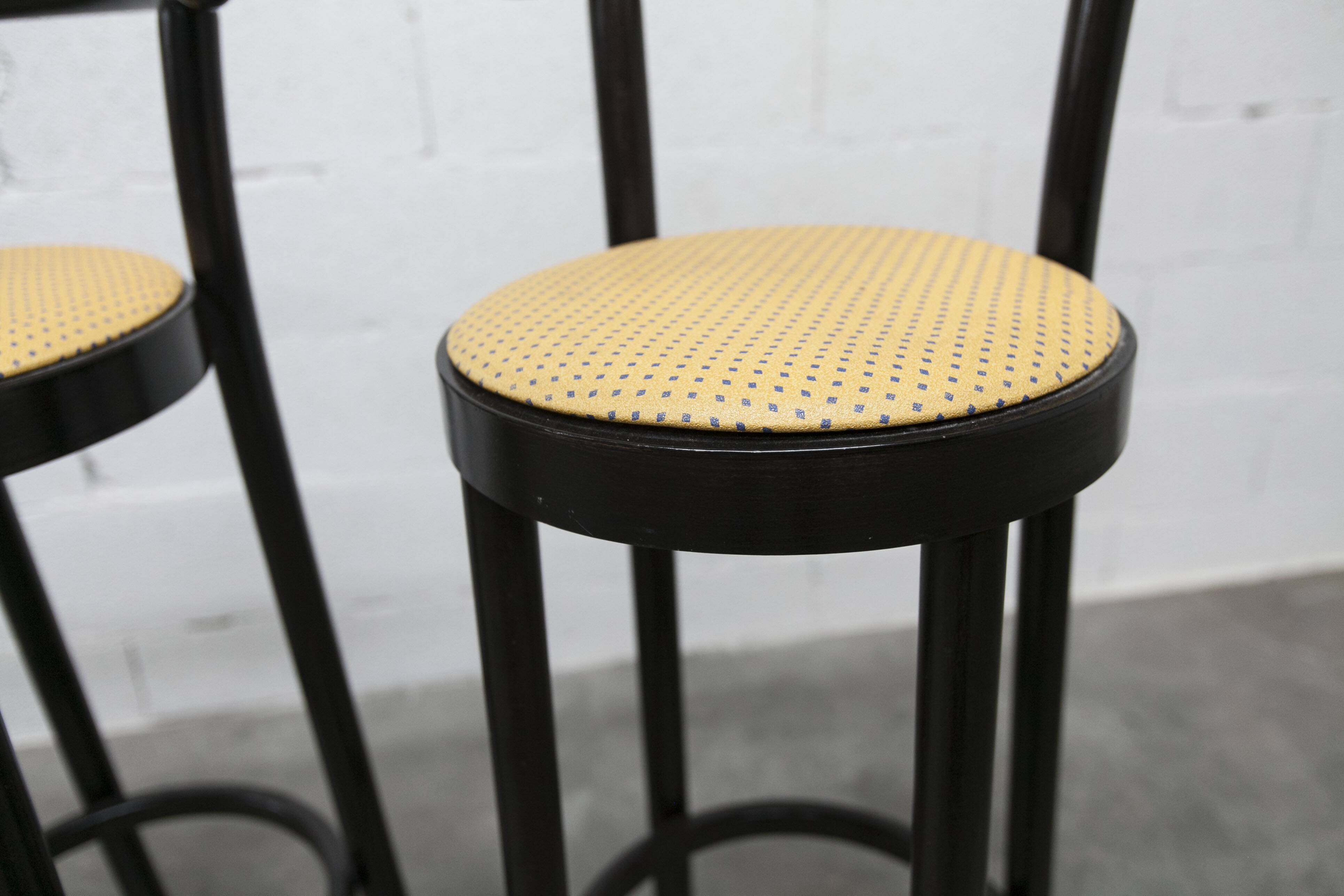 Pair of Baumann Dialog model stools in black and yellow and blue imitation leather, 1990