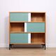 A vintage mid-century 3 tiered bookcase with glass sliding doors