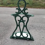 Bottle green enamelled cast iron umbrella stand with a swirl design.