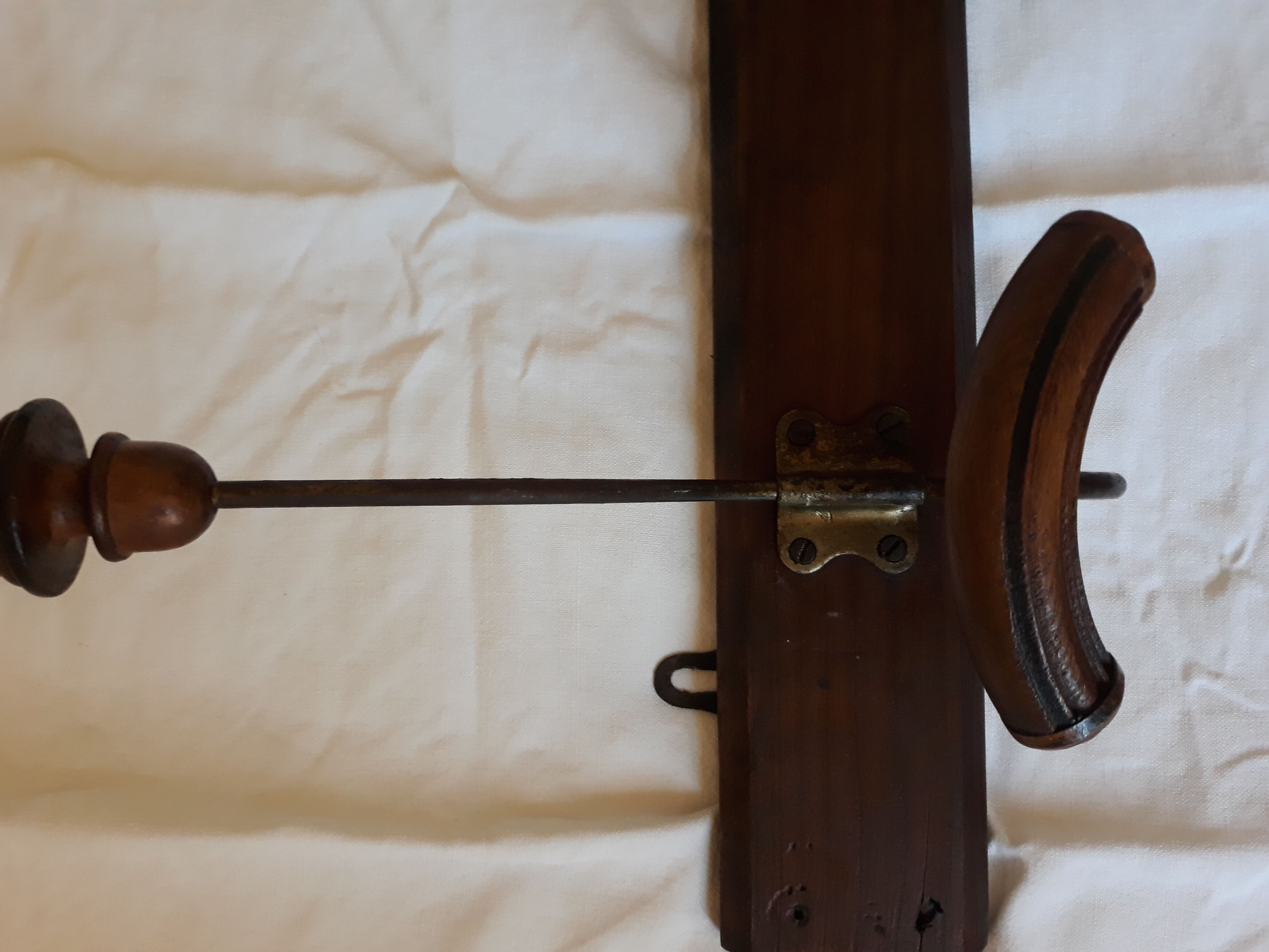 old wall coat holder made up of 3 wooden and metal pads.