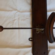 old wall coat holder made up of 3 wooden and metal pads.