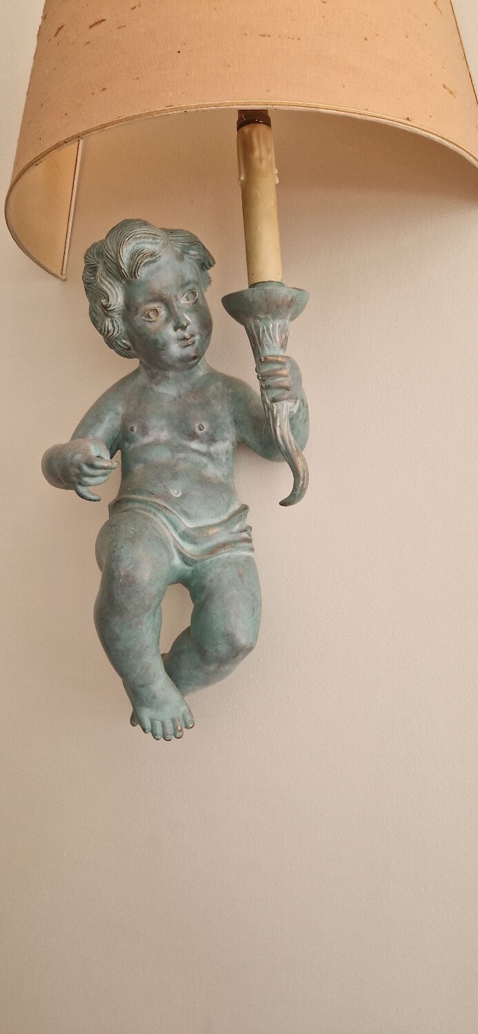 Pairs of wall lights, either two distinct cherubs.