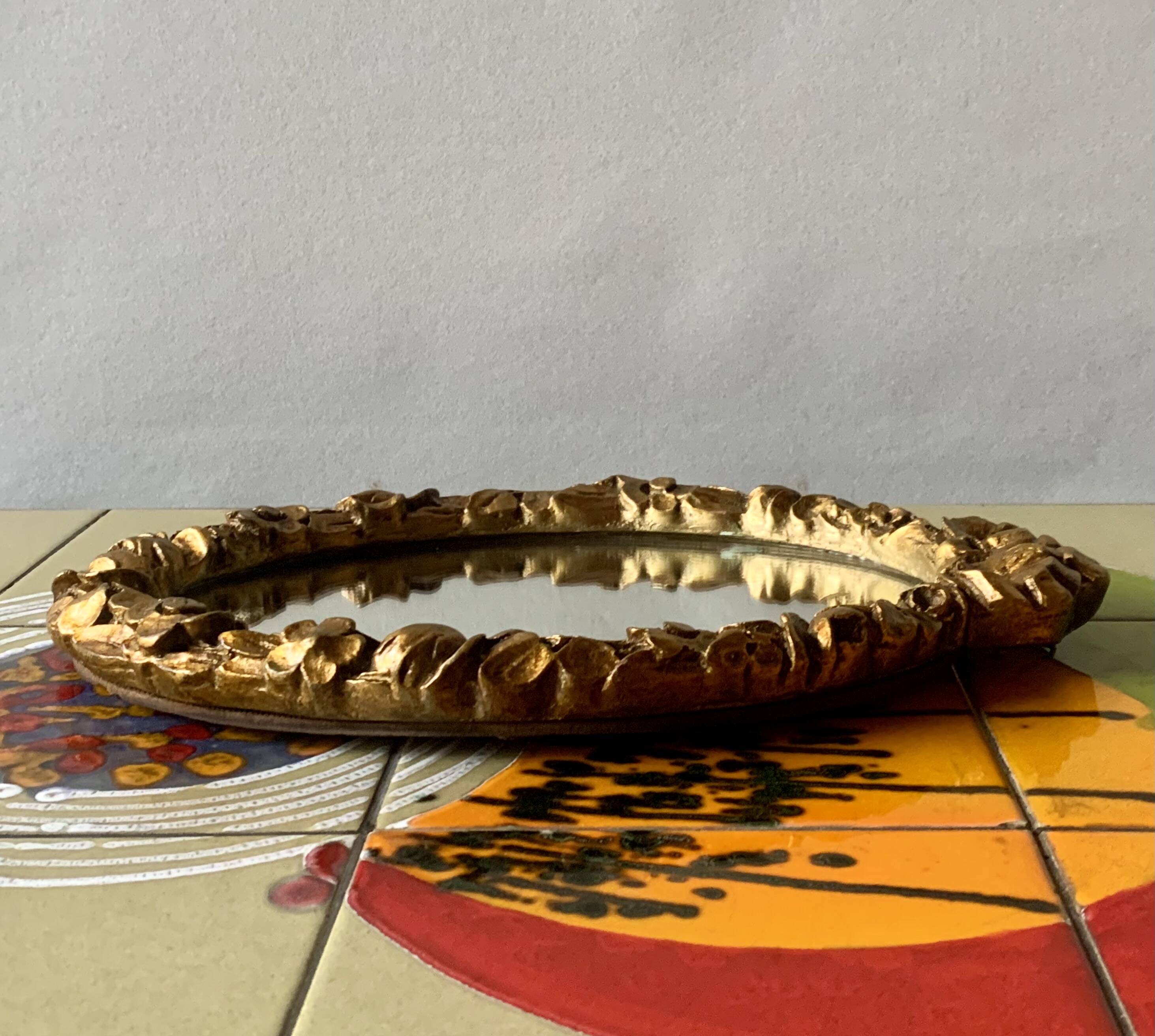 Small vintage oval wall mirror in varnished gold resin