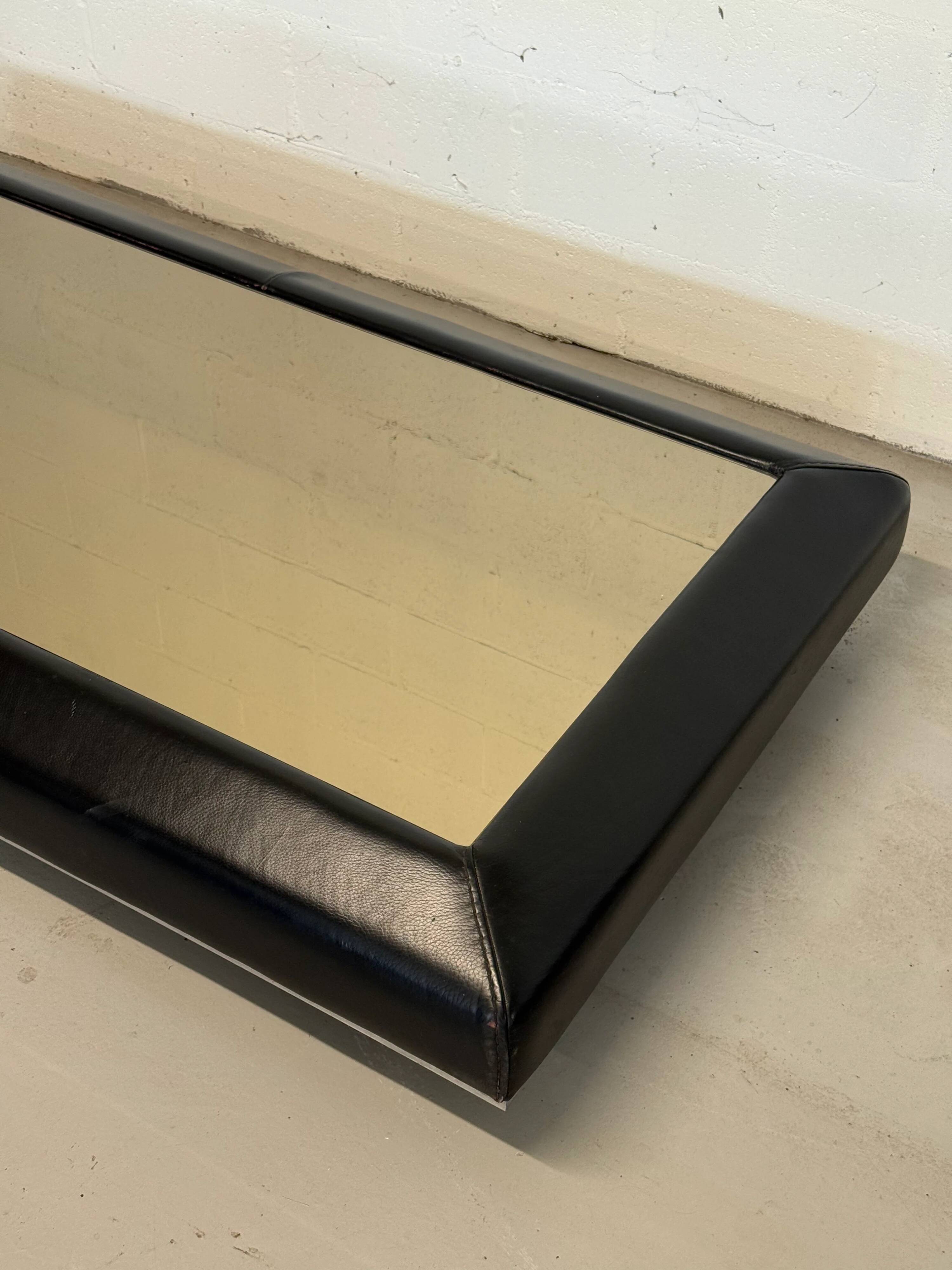 Vintage coffee table covered in leather, smoked mirror top and chrome legs.