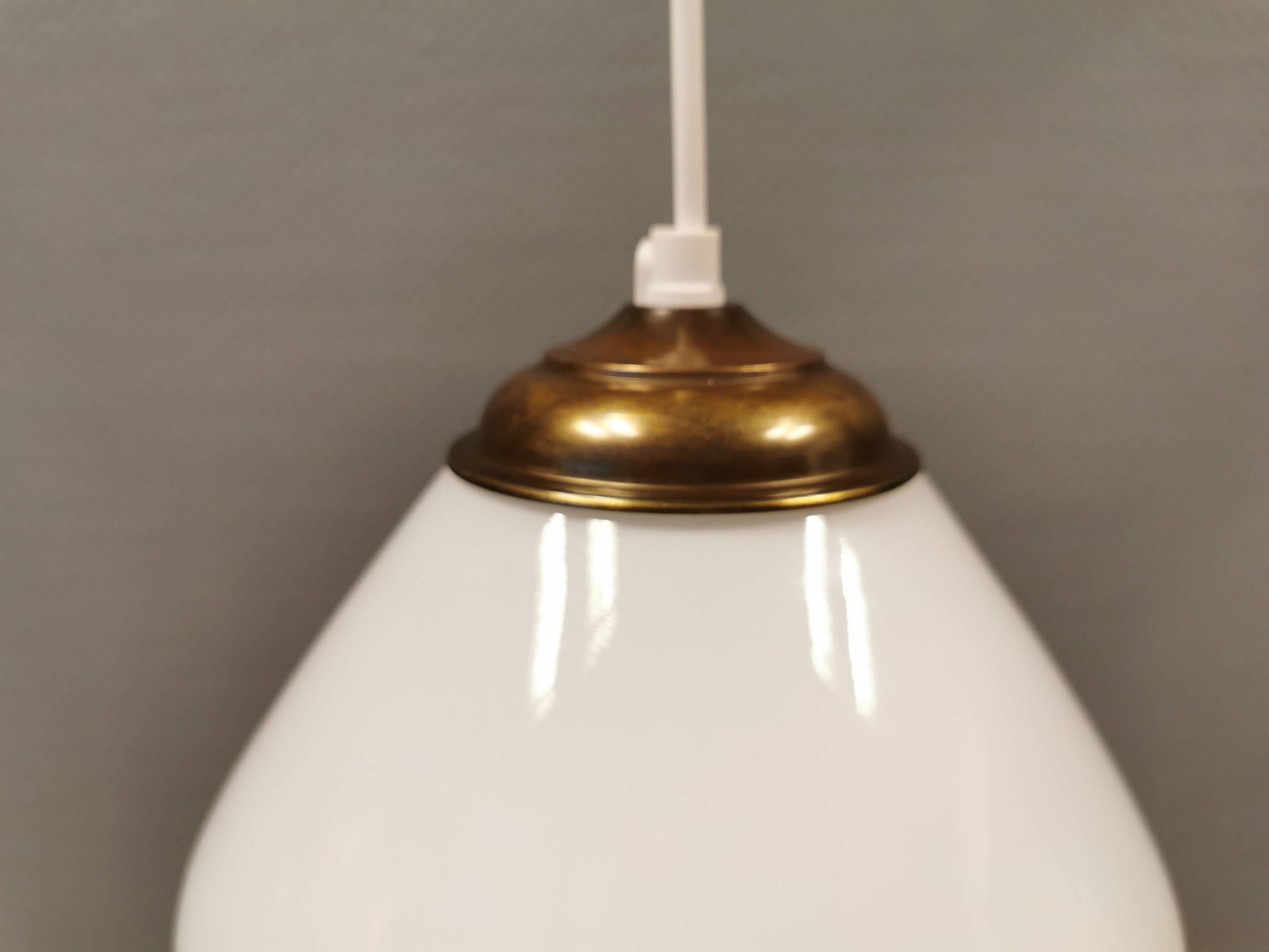Beautiful ball-shaped hanging lamp in white opal glass with brass top.