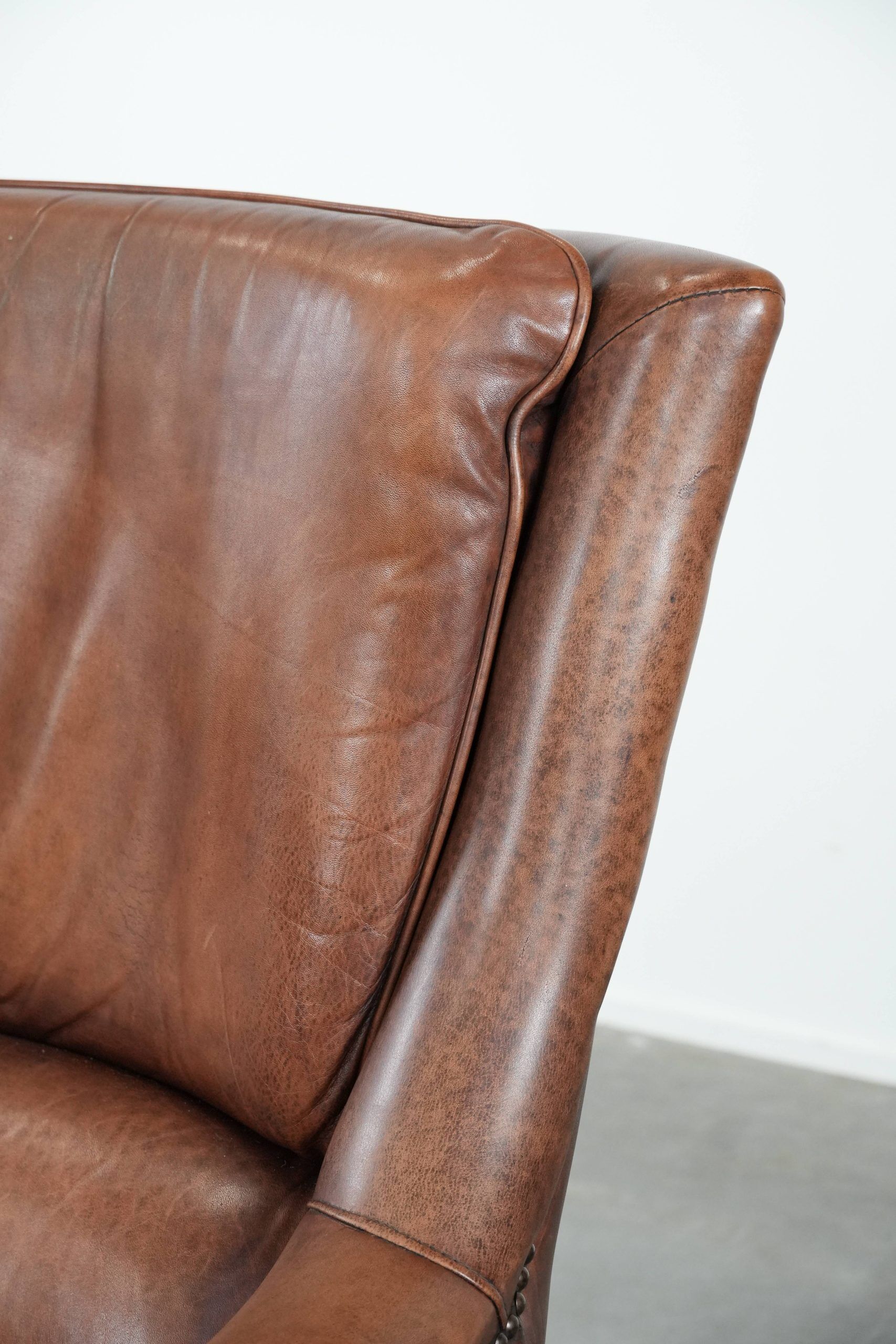 Cognac brown cow leather armchair with decorative nail finish