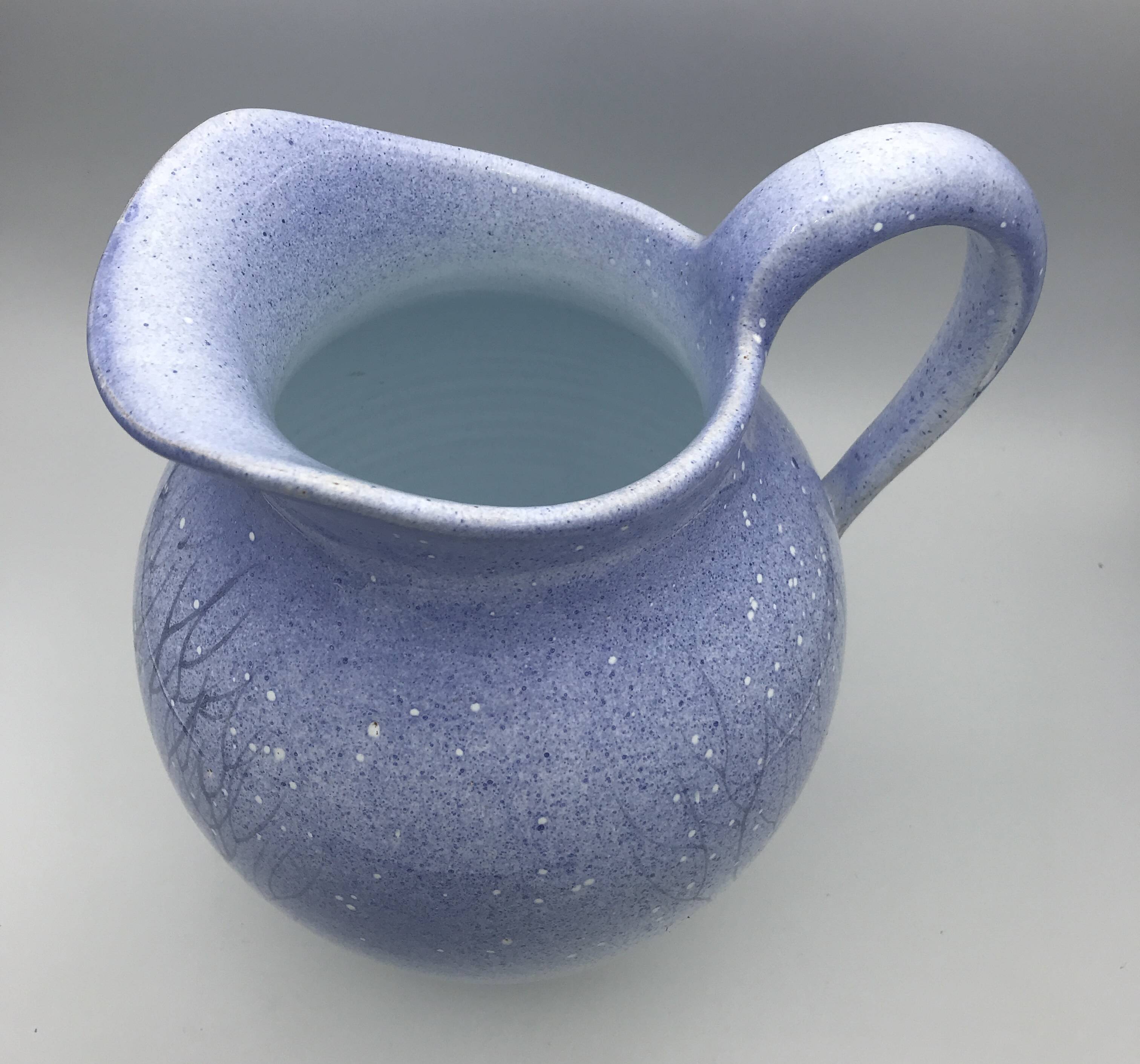 Blue glazed terracotta pitcher with hand-painted decoration, signed