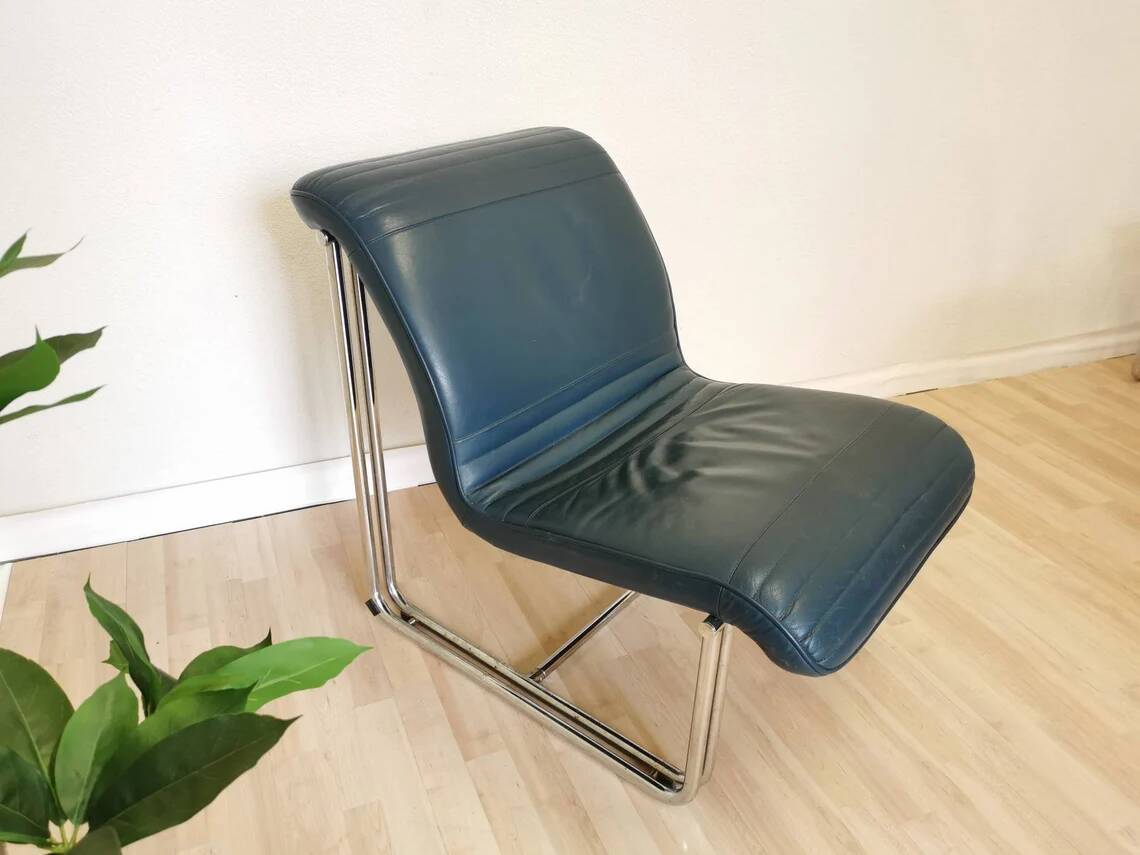 Fauteuil lounge vintage en cuir bleu marine : structure tubulaire chromée, style italien futuriste