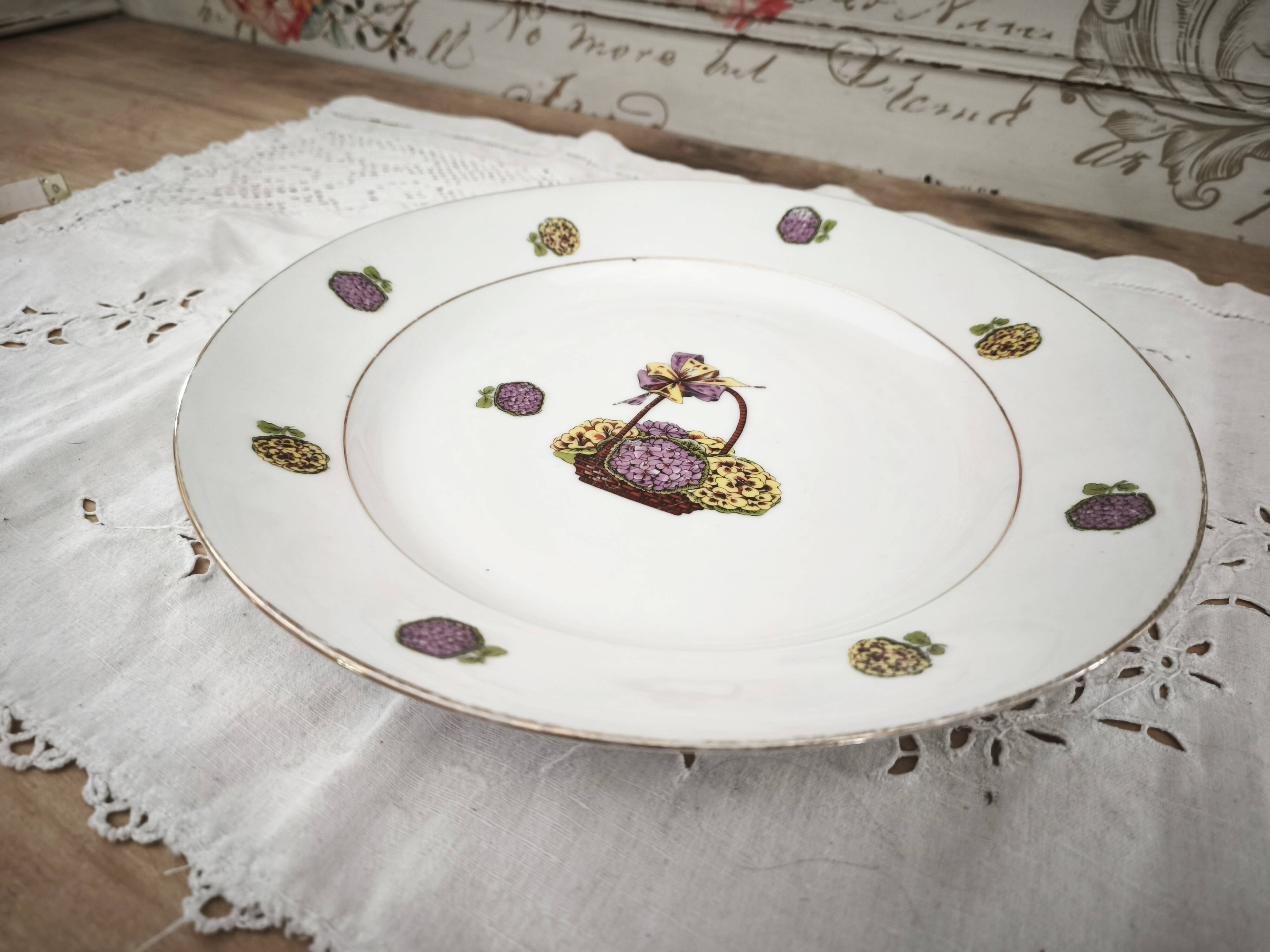 Round porcelain plate from Limoges with a hydrangea basket design.