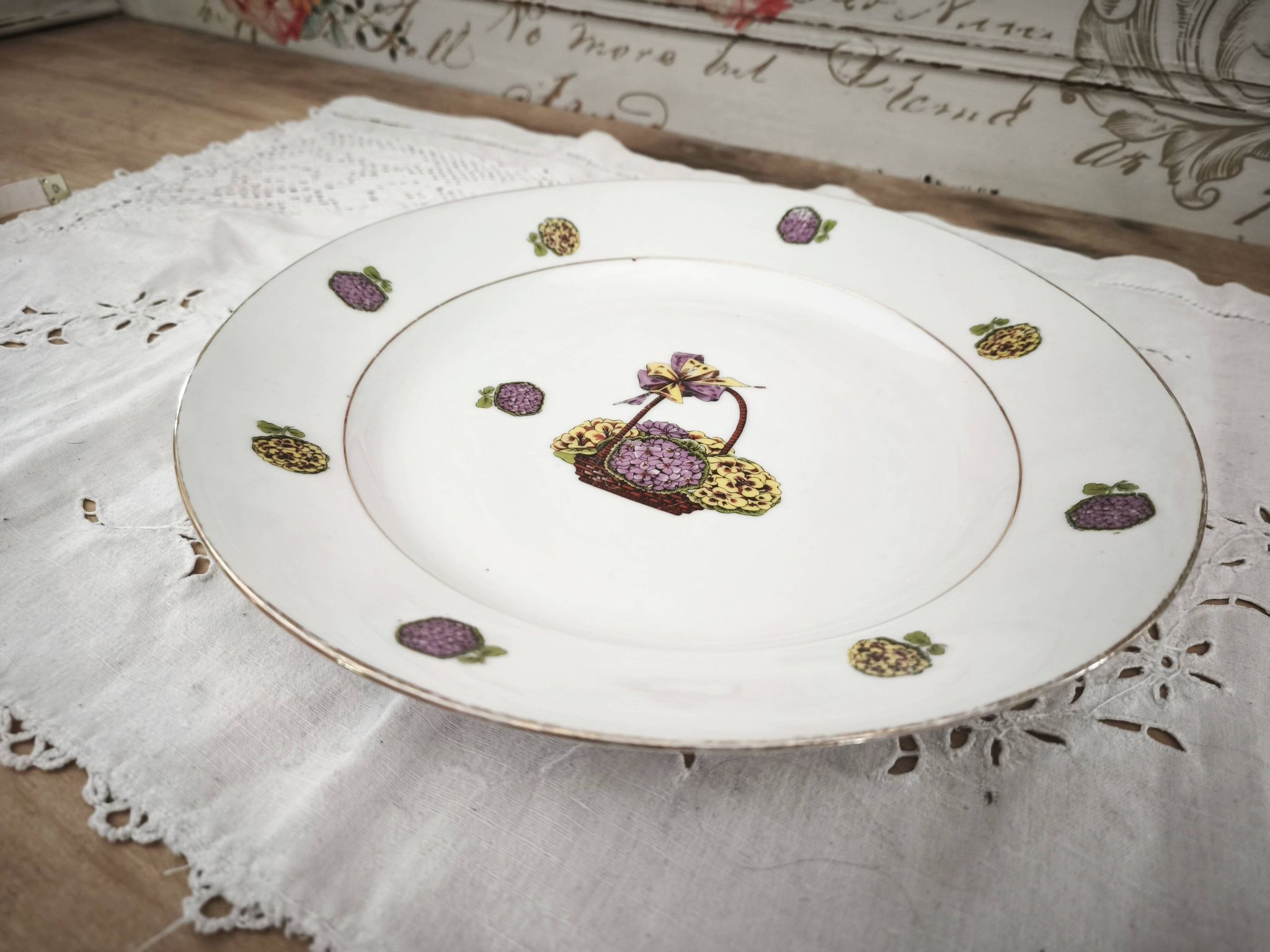 Round porcelain plate from Limoges with a hydrangea basket design.