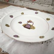 Round porcelain plate from Limoges with a hydrangea basket design.