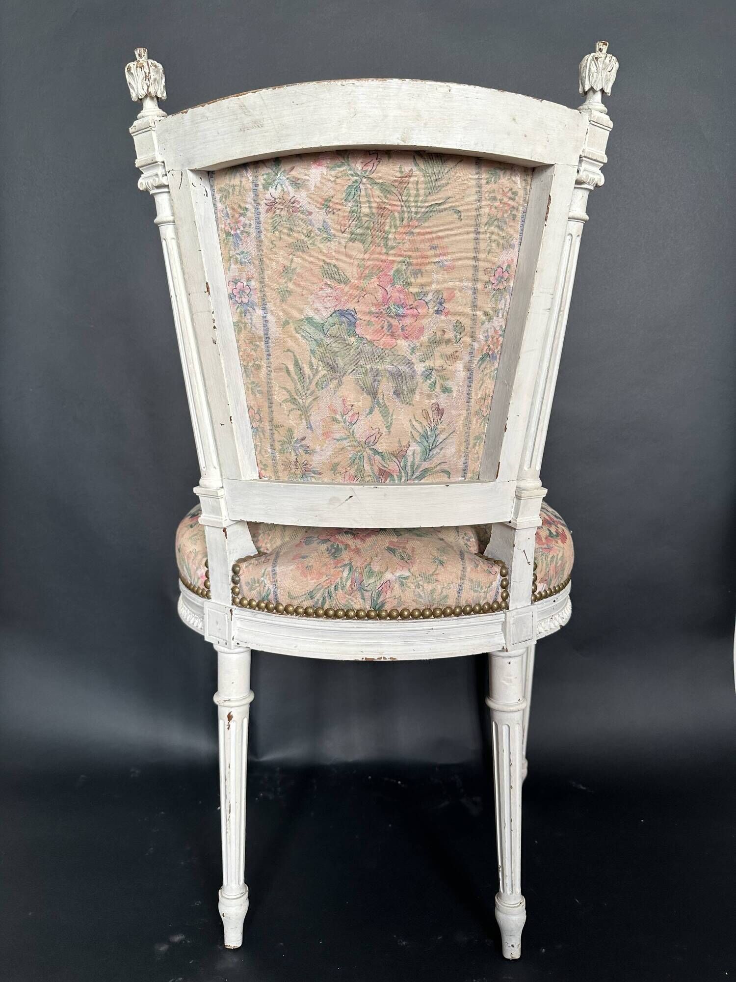 Antique Louis XVI style chair with patinated wood and floral fabric.
