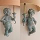 Pairs of wall lights, either two distinct cherubs.