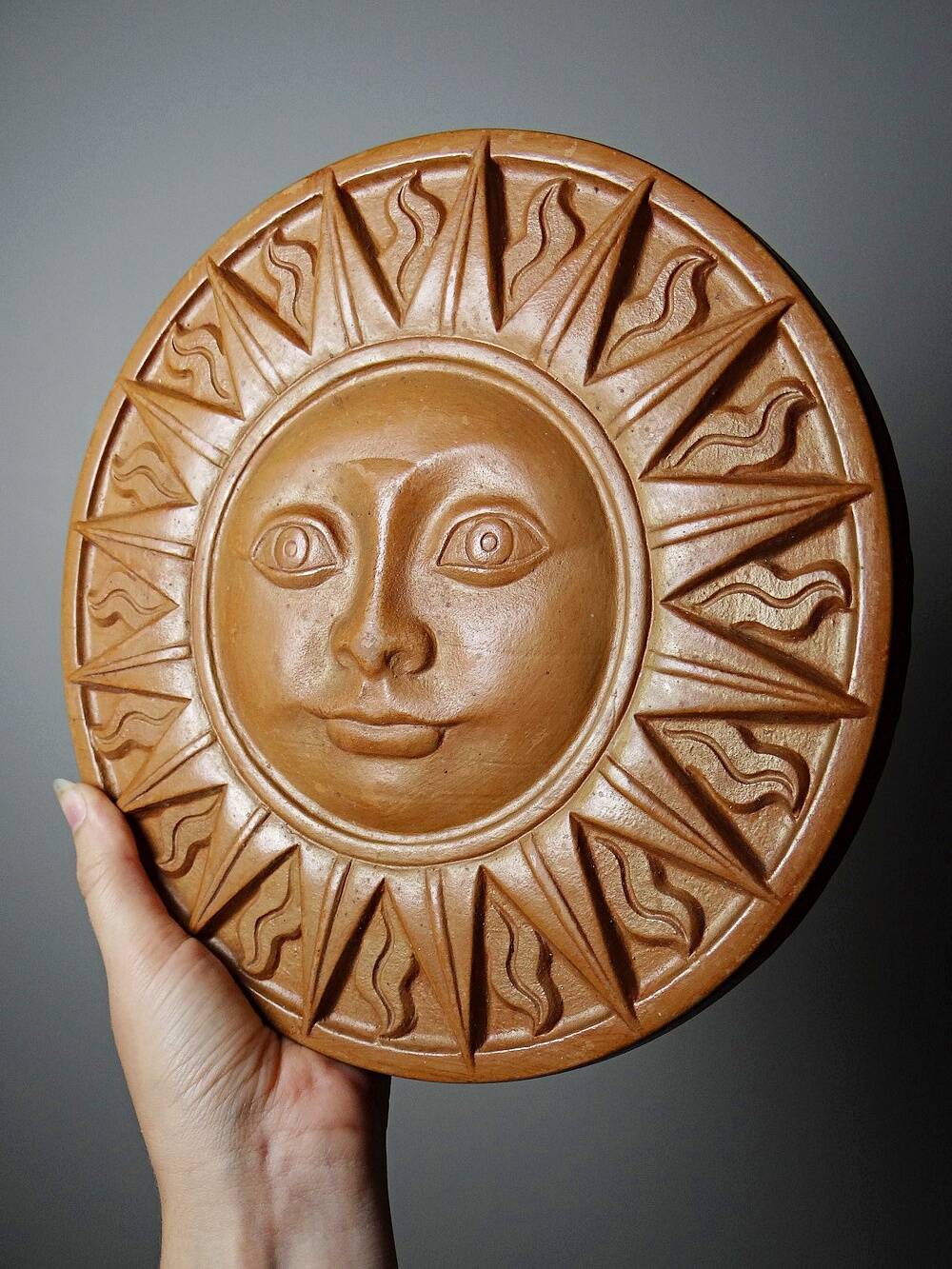 Plaque murale soleil anthropomorphe en terre cuite patinée, Italie 1996