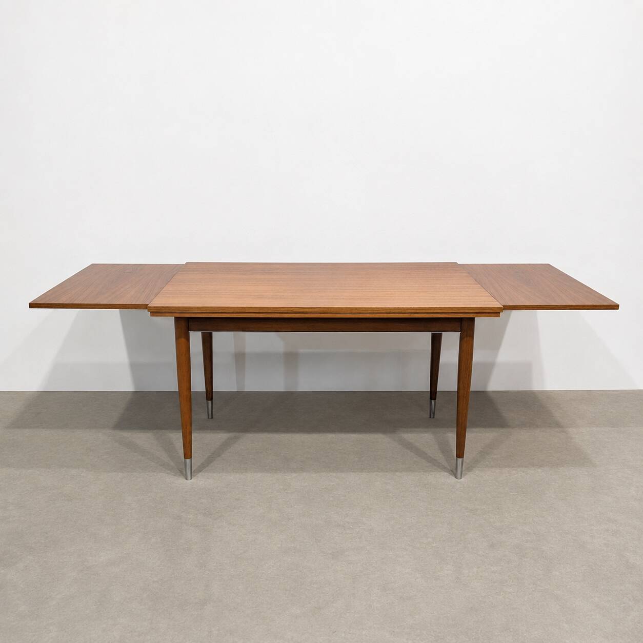 Vintage extendable dining table with tapered legs.