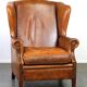 Positively lived-in sheepskin leather wing chair with pleasant seating comfort