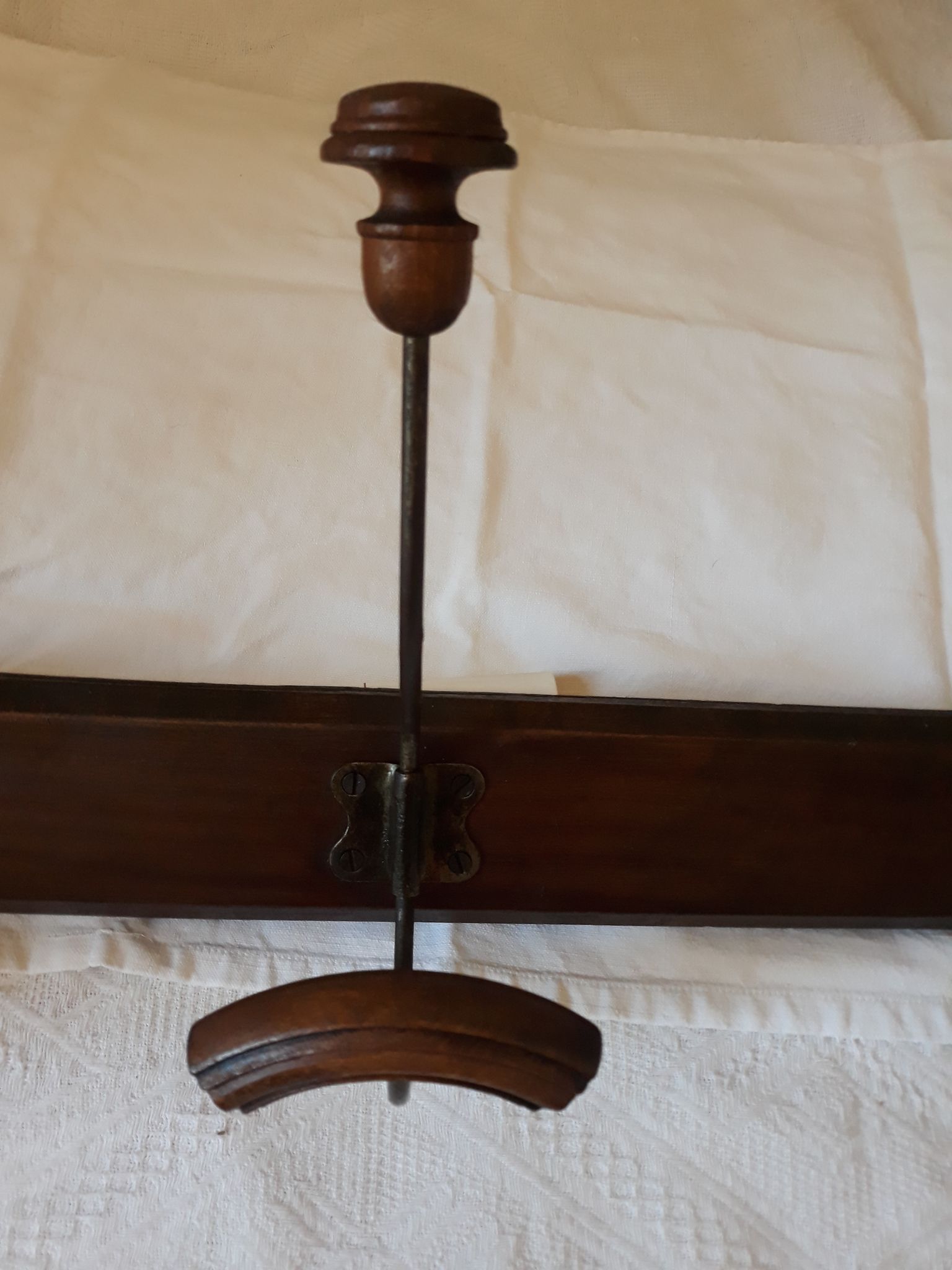 old wall coat holder made up of 3 wooden and metal pads.