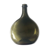 Old rum bottle in thick puffed glass in dark green color