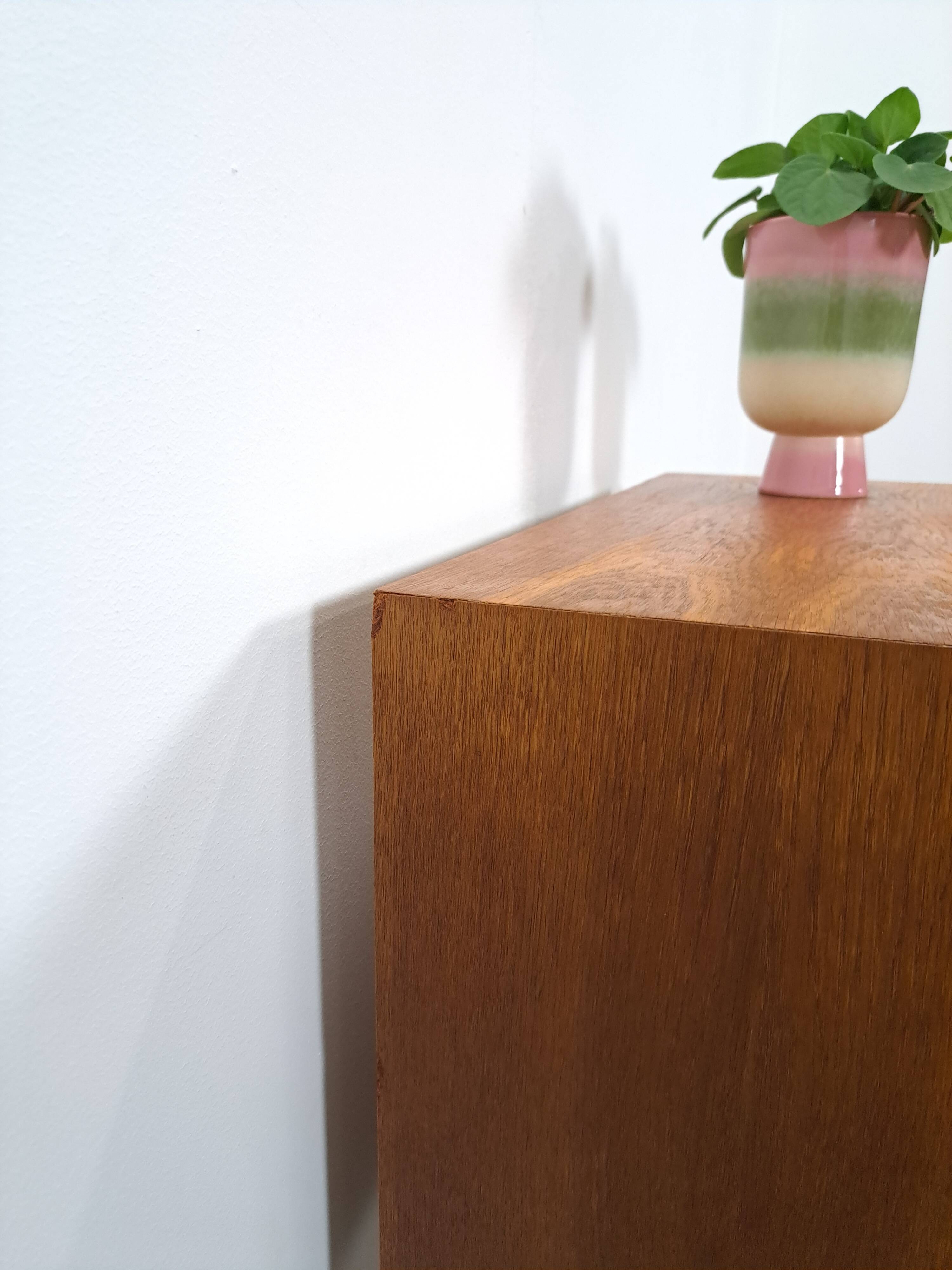 Commode danoise avec de hauts pieds et des poignées dorées.
