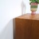 Commode danoise avec de hauts pieds et des poignées dorées.