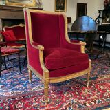 Golden wooden bergère in Louis XVI style upholstered in Bordeaux velvet.