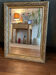 Golden mirror with an antique wooden and stucco frame.