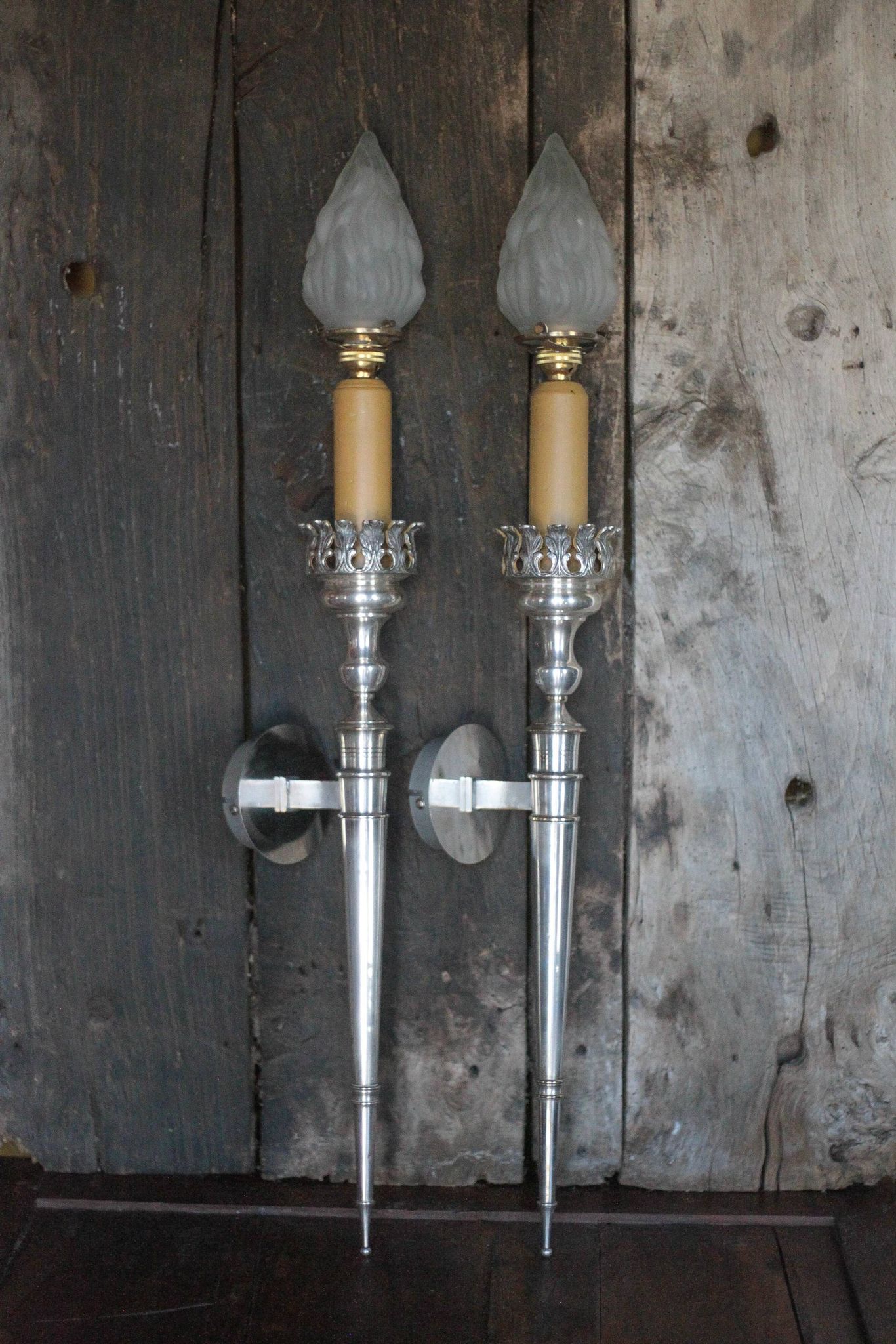 Large pair of silver-plated wall lights with flame globes, torches.