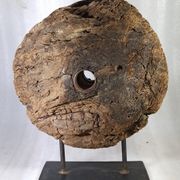 Old wooden pulley wheel on foot