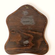 Antique wall mirror in carved wood with a wavy shape and a golden trim.