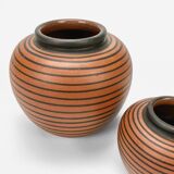 Pair of Elchinger ball vases with asymmetrical black stripes on an auburn background