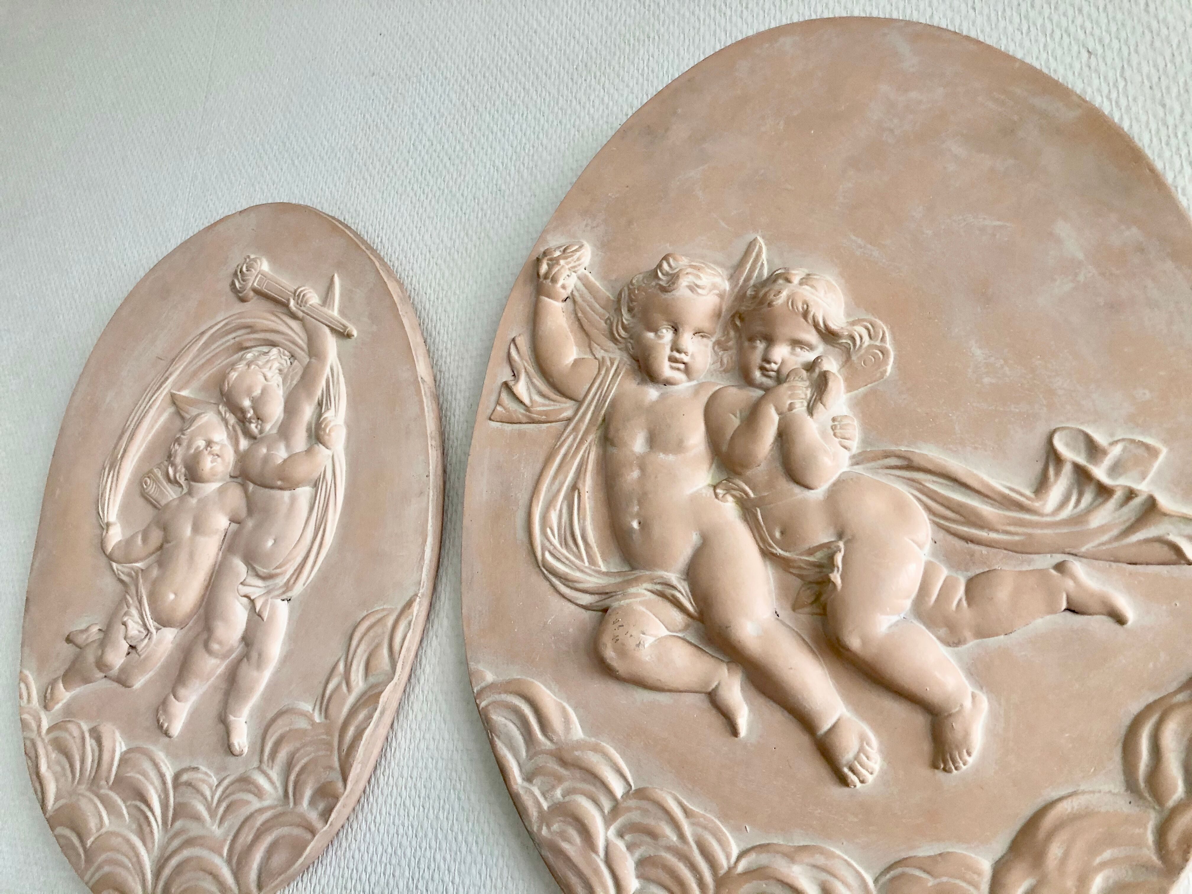 Pair of putti medallions