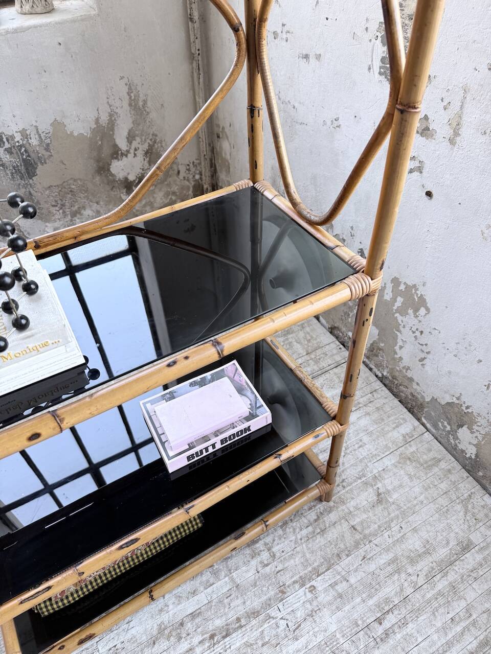 Rattan bookshelf and black glasses