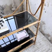 Rattan bookshelf and black glasses