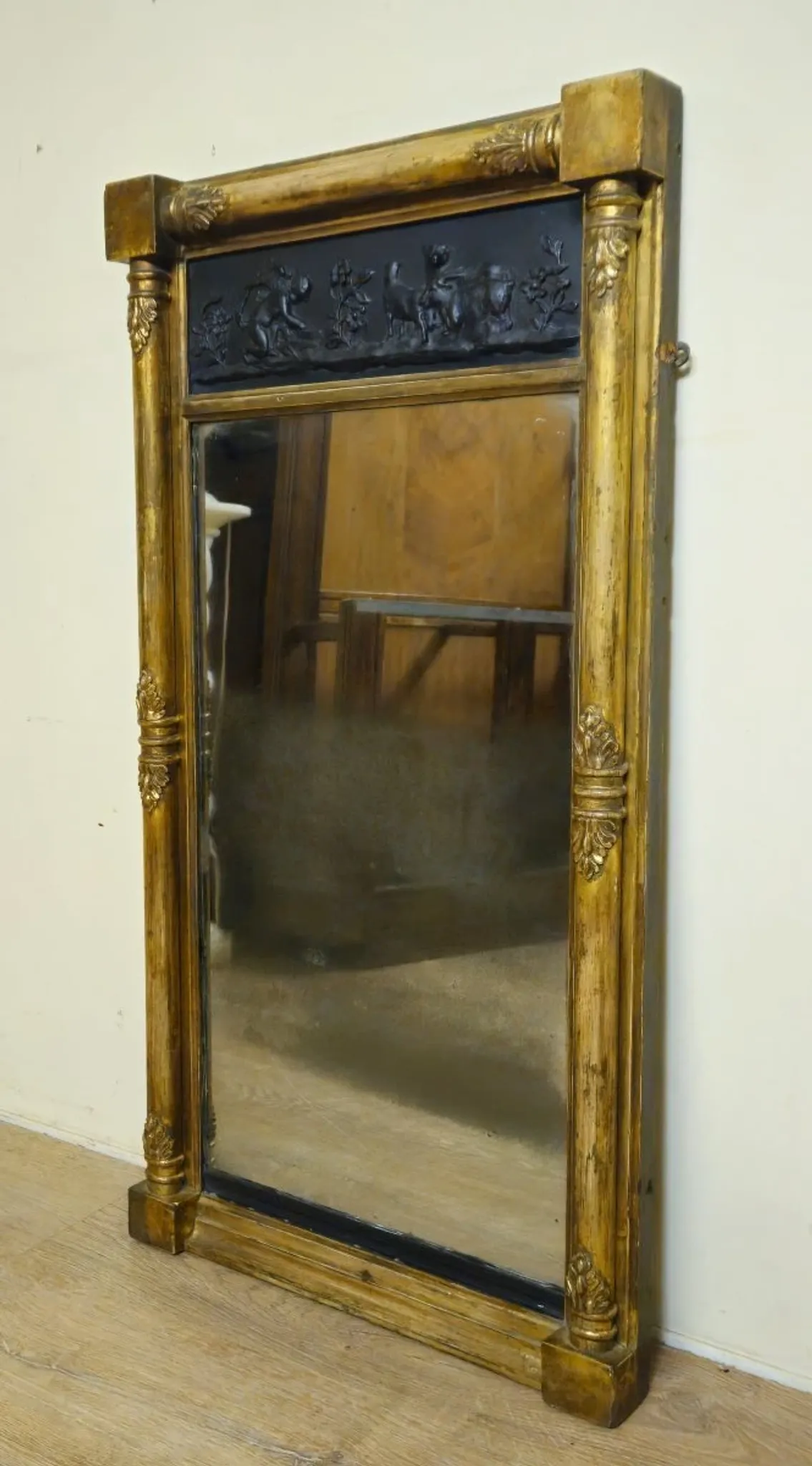 Large antique gilded wooden mirror with terracotta relief from the Empire period.