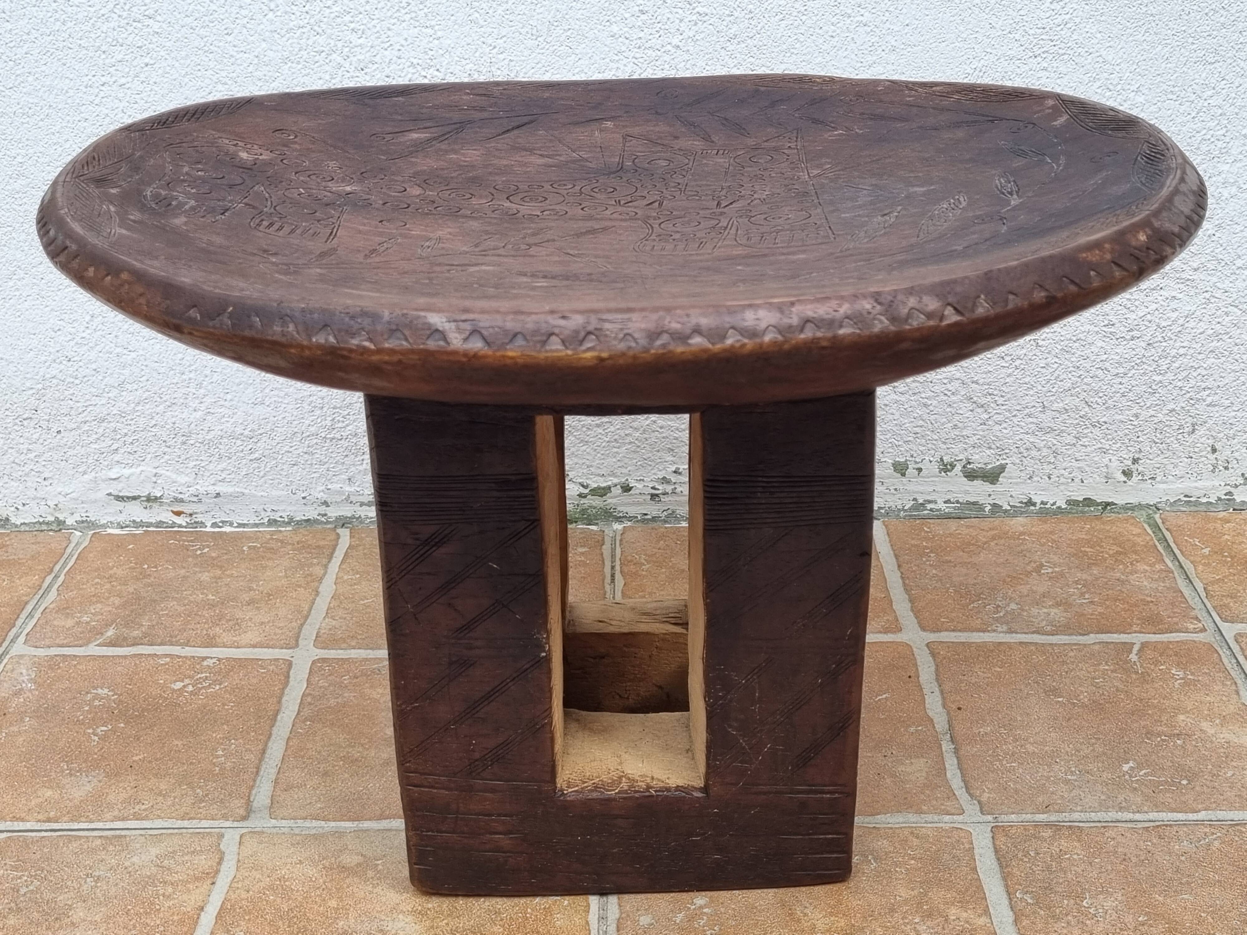 African monoxyle side table in carved wood with a curved top, 48x36 cm.