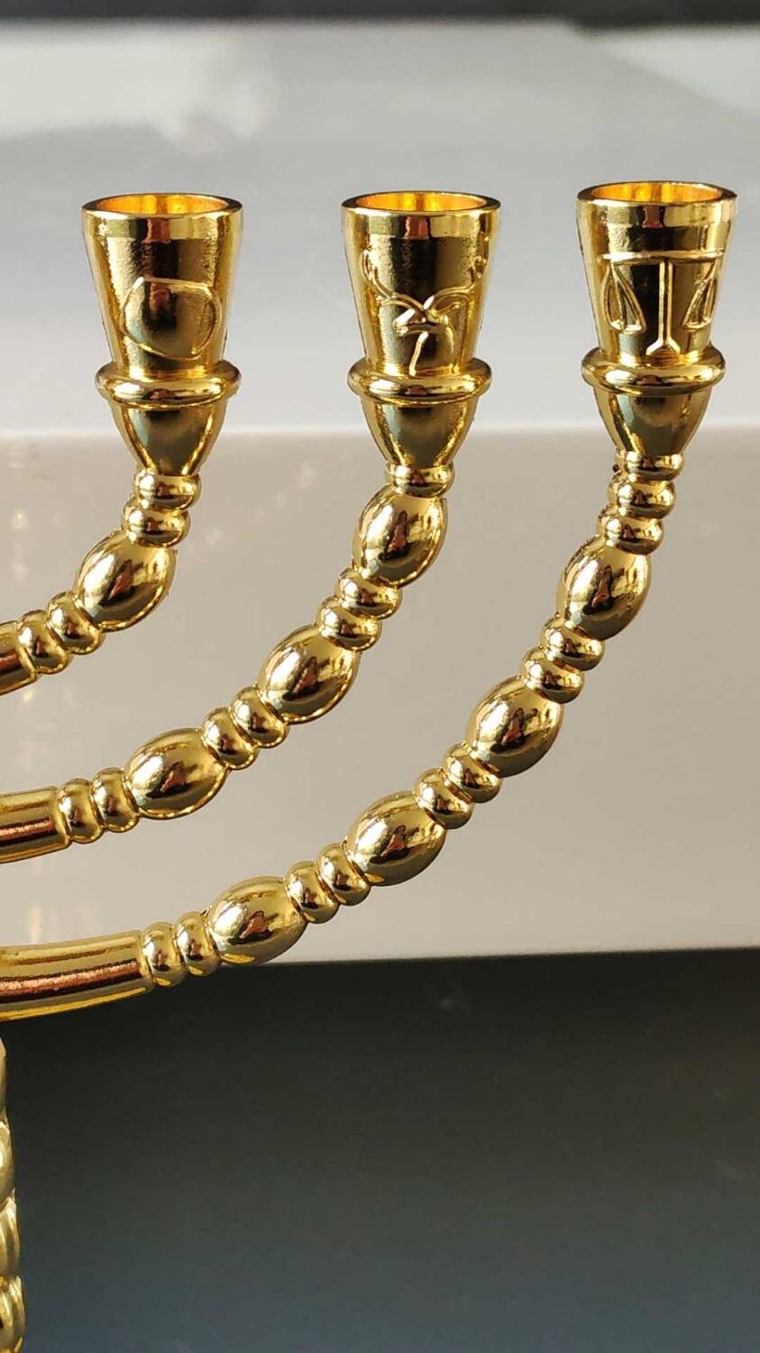 Menorah/Jewish/Hebrew candlestick with 7 arms of light. Engraved with the symbols of the 12 tribes of Israel/Holyland inscription. In gold metal. Size 20 x 16 cm