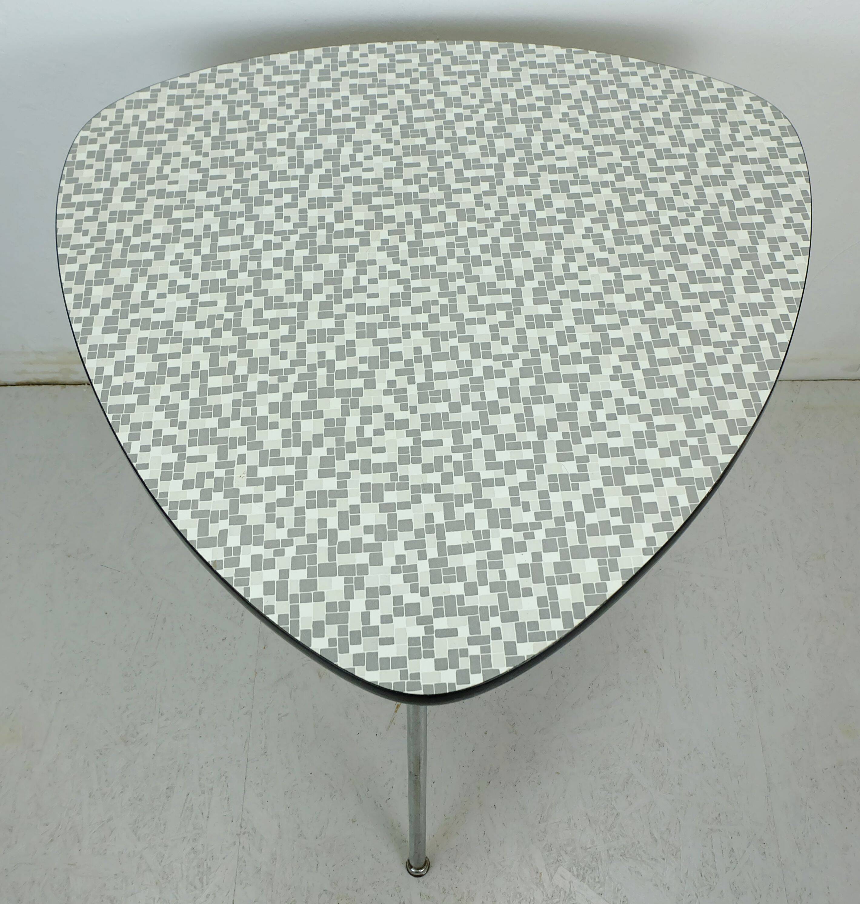 Table basse des années 1950 à trois pieds avec un plateau en formica et des pieds en chrome inclinés.